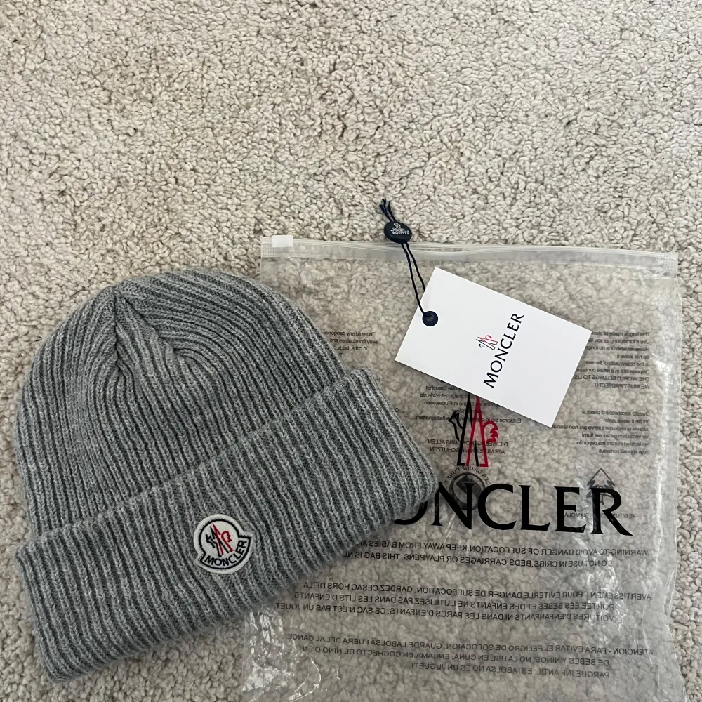 Säljer denna gråa mössa från Moncler. Den är i bra skick och är riktigt snygg. Passar för kalla dagar. Dustbagen ingår i köpet.. Asusteet.