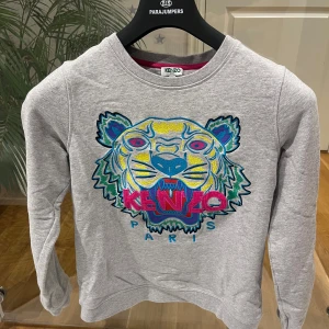 Grå kenzo tamaño sweatshirt  - Säljer en super fin grå kenzo tamaño sweatshirt i storlek S. Skick:10/10 inget slitage eller något liknande spår. Nypris 2000kr,  tröjan säljs för endast 500kr. Tveka aldrig att höra av dig/kevin
