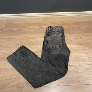 Mörkgrå jeans från ASOS Design - Snygga mörkgrå jeans från ASOS Design i en klassisk straight fit. De har en midwaist och är tillverkade i ett slitstarkt denimtyg. Perfekta för en stilren look. Pris kan diskuteras