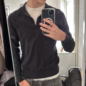 Svart tröja med dragkedja från These Glory Days - Snygg svart tröja från These Glory Days i Superior Cotton. Tröjan har en dragkedja vid halsen och långa ärmar. Perfekt för en stilren look. Nypris :1000. Använd fåtal gånger