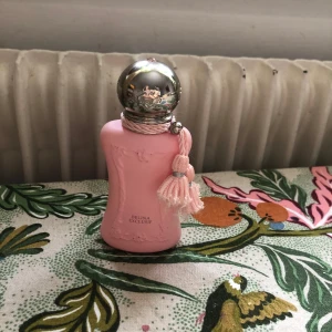 Delina Exclusif Parfums de Marly - Delina exclusif är en sötare tolkning av originalet Delina. Detta är en orientalisk rosdoft. I öppningen får man en burst av fruktighet från päron men framförallt lychee. I drydown kommer vaniljen fram mer och gör den till en sockrig fluffig ros. Skulle kunna jämföras med turkisk konfekt. Hållbarhet och projektion är mycket god, särskilt på kläder. Delina Exclusif är en beastmode och 1-3 sprejs håller långt. Originalpris för 30 ml är 1890. Se bild 2 för mängd. Kund står för frakt