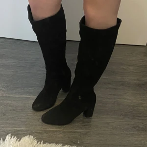 Svarta knähöga stövlar med klack - Snygga svarta stövlar i mocka med klack och dragkedja på sidan. Köpta för 899, använda en gång🎩🤩
