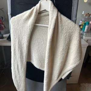 Beige halsduk från Opus - Säljer en mjuk och stilren beige halsduk från Opus. Perfekt för att hålla dig varm under kyliga dagar. Den har en enkel design som gör den lätt att matcha med olika outfits.