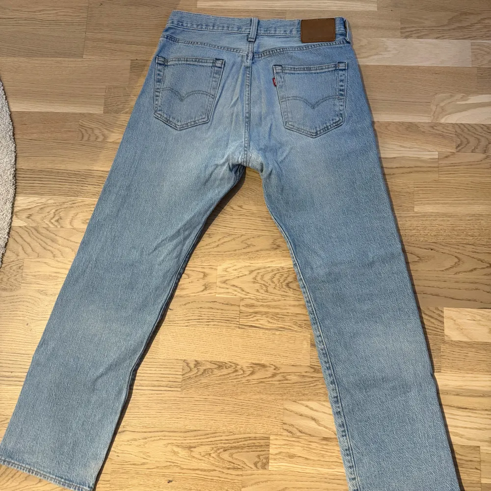 Säljer ett par klassiska ljusblå Levi's 501 jeans. De har en rak passform och är tillverkade i slitstarkt denim. . Farkut & Housut.