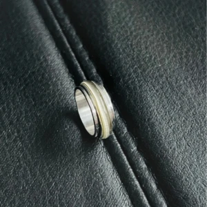 Lustrous Steel: Silver Glas Ring - En stilren ring i rostfritt stål med en inre diameter på 17,3 mm, omkrets 54,4 mm och storlek US 7. Glasbandet i grå/silver nyans reflekterar ljuset vackert och ger ringen en modern, minimalistisk look.