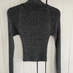 Glittrig svart tröja från Gina Tricot - En superfin oanvänd glittrig svart tröja från Gina Tricot i storlek XS. Tröjan har en tight passform. Perfekt för en festlig look ✨