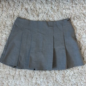 Grå minikjol - Grå plisserad kjol från Pull&Bear med dragkedja i sidan. Kjolen är kort och har en väldigt fin passform men tyvärr lite för stor för mig därför är den enbart provad ✨Slutsåld på ASOS där jag köpte den. Skriv om du har funderingar eller vill ha mått 💞