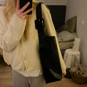 Svart axelväska med justerbart spänne - Snygg svart axelväska med ett brett justerbart spänne. Kommer inte till användning längre men knappt använd💓🥰