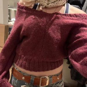 Vinröd stickad offshoulder tröja - Säljer en vinröd stickad offshoulder tröja! Tröjan har långa ärmar och ribbade kanter, klippt för att vara offshoulder. 100% ull, använd max 2 gånger! Passar S.