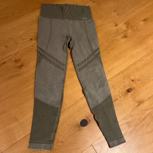 Gröna leggings från Aim'n - Snygga gröna leggings från Aim'n med ribbad midja och texturerade detaljer längs benen. Perfekta för träning eller en avslappnad dag. Tillverkade i ett stretchigt material för bästa komfort.