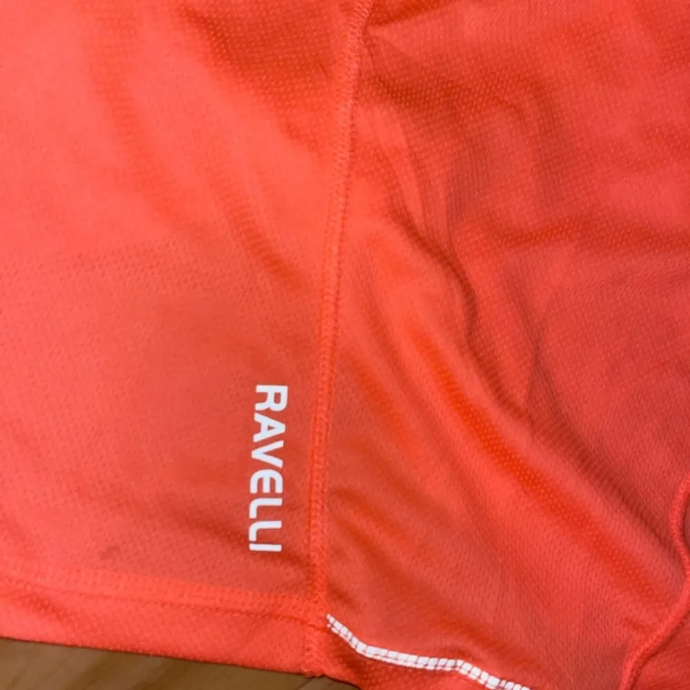 Säljer en neon rosa träningstopp från Ravelli i storlek M. Toppen är kortärmad och har en v-ringad design. Perfekt för träning med sitt lätta och bekväma polyester-material.. Neuletakit & Villapaidat.