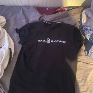 Svart t-shirt från Sail Racing - Säljer nu en svart Sail Racing T-Shirt som är väldigt fräsch fick den som present och bara prövat på den en gång.
