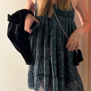 Mönstrad klänning med smala axelband från Meet me There - Säljer en snygg mönstrad klänning i mörkgrön nyans med smala axelband. Klänningen har ett fint fall och ett elastiskt livstycke som ger en bekväm passform. Perfekt för sommarens alla tillfällen!