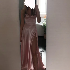 Rosa sidenklänning med slits - Säljer min fina rosa balklänning pga ingen användning längre💕den är i storlek XS och passar mig som är 168/169cm lång. Har en slits och en fin snörning i ryggen
