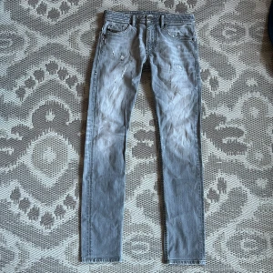Grå jeans från Diesel - Snygga grå jeans från Diesel med en straight passform. De har en klassisk femficksdesign och en diskret sliten look. Perfekta för en avslappnad stil.