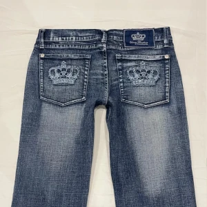 Snygga Victoria Beckham jeans - Jätte snygga lågmidjade jeans från Victoria Beckham. Köpta för 1200. Midjan rakt över är 41 cm, innerbens längden är 74 cm och gren höjden är 19,5 cm. Skulle säga att de är ett lite större S eller liten M. Väldigt bra skick förutom att några av stenarna har ramlat av och de är kortade av tidigare ägare. 