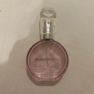 Parfym från Ariana Grande - Säljer en parfym från ariana Grande i 30ml, den har varit öppnad ett tag och har används lite, kristallen som parfymen ska stå i är borta så det är bara parfymen. Toppnoter: fikon, salt och karamell. hjärtnoter: lavendel och päronblomma. Basnoter: mysk, tonkabörna och sandelträ!💓