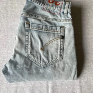 Ljusblå skinny jeans från Dondup - Snygga ljusblå skinny jeans från Dondup med en klassisk femficksdesign. De har en dragkedja och knapp framtill samt subtila slitningar för en trendig look. Perfekta för en stilren outfit.