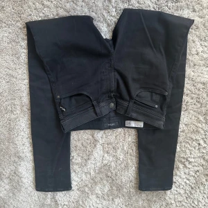 Svarta jeans från Replay - Snygga svarta jeans från Replay med en stilren design. De har en klassisk femficksmodell och är tillverkade i ett stretchigt material för extra komfort. Storlek 16 år alltså största storlek i barnmodell. Slim fit. Passar mig som är 175 cm. Bara att höra av dig vid frågor.