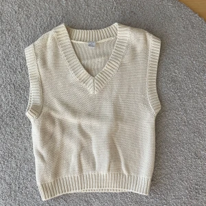 Beige stickad väst - Säljer en stilren beige stickad väst med v-ringning och ribbade kanter. Storlek 170 men skulle säga att den passar xs/ s