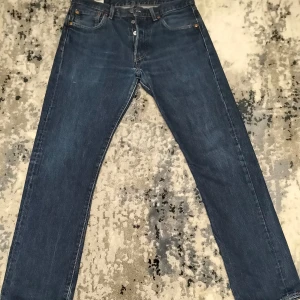 Blå jeansbyxor - Snygga blå jeansbyxor med klassisk femficksdesign och knappgylf. De har en rak passform och är perfekta för en avslappnad stil. Märkeslappen i brunt läder på baksidan ger en autentisk touch.