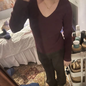 Vinröd ribbad tröja - Säljer en vinröd ribbad tröja med v-ringning. Tröjan har långa ärmar och en tight passform, perfekt för höst och vinter. En stilren och bekväm tröja som passar till många tillfällen.