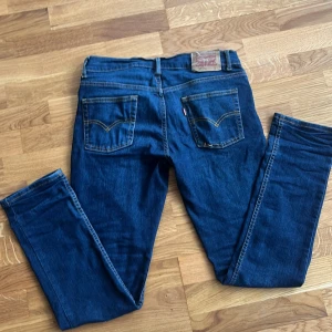 Levis 512 Slim Taper Jeans - Snygga Levis 512 Slim Taper jeans i en klassisk blå färg. De har en smal passform med avsmalnande ben och är tillverkade i jeansmaterial. Perfekta för en stilren look. Vi snabba affär kan priset gå ner 