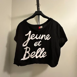 Svart croppad t-shirt  - Snygg svart croppad t-shirt med vit text på framsidan från HM i storlek M. 