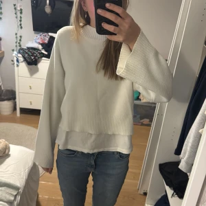 Vit stickad tröja - Säljer en superfin vit stickad tröja med långa ärmar. Den har en avslappnad passform och är perfekt för både höst och vinter. Tröjan är i bra skick och passar perfekt till jeans för en casual look. Perfekt för mysiga dagar hemma eller en promenad i parken.