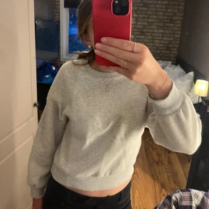 Grå sweatshirt - Säljer en supermysig grå sweatshirt i bra skick från ginatricot. Perfekt för en chill dag hemma men går även att klä upp. Den har långa ärmar och en normal passform. 