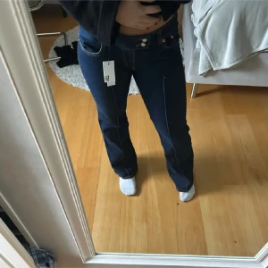 Mörkblå jeans med bootcut - Säljer ett par snygga mörkblå jeans i bootcut-stil. De är lågmidjade. Storlek 34! Nu utan prislapp, lappen ramlade av. Nypris: 400kr