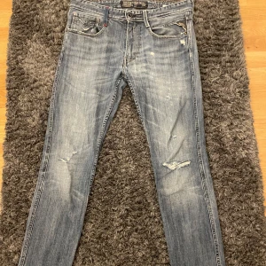 Replay Jeans Anbass - Säljer ett par snygga blå jeans från Replay i bra skick. De har en slim passform och är perfekta för både vardag och fest. Jeansen har snygga slitningar!  Hör av dig vid funderingar 