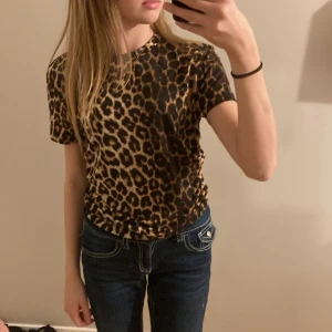Leopardmönstrad t-shirt från SHEIN - Säljer en snygg leopardmönstrad t-shirt från SHEIN i storlek L. Den är kortärmad och har en tight passform, perfekt för en cool och trendig look. Materialet är mjukt och stretchigt, vilket gör den bekväm att bära. Passar perfekt till både vardag och fest! 🐆✨aldrig använd då jag köpte fel storlek, köparen står för frakt💕💕