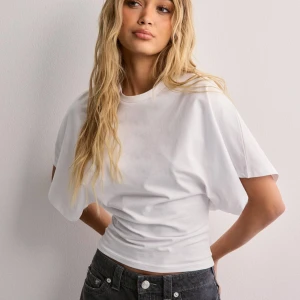 Round Neck Wide Sleeve Tee - (Lånade bilder från hemsidan) Är slutsåld! Säljer denna snygga toppen från Nelly som jag glömde skicka tillbaks. Är oanvänd och prislappen är kvar. Perfekt för både vardag och fest. Är figursydd och sitter jättesnyggt med ett skönt material. 