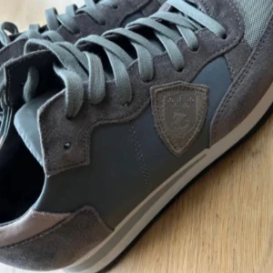 Blå sneakers från Philippe Model - Säljer ett par snygga grå sneakers från Philippe Model i storlek 39 och en halv. Perfekta för både vardag och festliga tillfällen. Tillverkade i Italien med hög kvalitet.