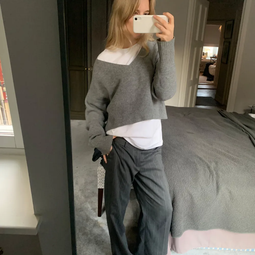 Säljer en supermysig grå croppad stickad tröja med v-ringning. Perfekt för lager-på-lager looken eller att ha för sig själv lite off-shoulder.  100% cashmere, sååå himla skön och snygg!. Tröjor & Koftor.