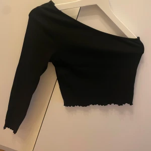 Svart oneshoulder topp - Snygg svart oneshoulder topp med lång ärm.