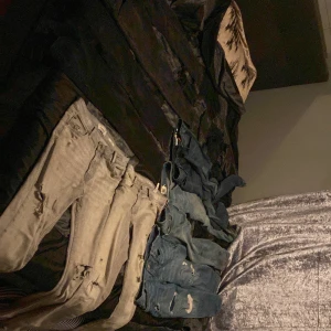 Samling av jeans i olika färger - Säljer flera par jeans i olika färger och stilar. De gråa jeansen har en sliten look med hål och är tighta. De blå jeansen är också slitna och har en mer avslappnad passform. Perfekta för en casual stil eller en utekväll. Hör av dig för mer info eller fler bilder! 80kr per styck