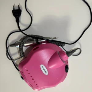 Elektrisk nagelfil  - Bild på en rosa elektrisk nagelfil med sladd och handstycke. Perfekt för manikyr och pedikyr hemma eller i salongen. Funkar perfekt.