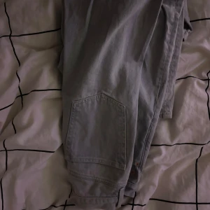 Baggy jeans från weekday  - Säljer ett par grå jeans från Astro i herrstorlek S. Nypris 600. De har en klassisk design med knappar och en bekväm passform. Perfekta för vardagsbruk och kan enkelt matchas med olika stilar. Astro modellen ger en snygg siluett trots att dome baggy pga att de sitter tight i midjan. Skicket är bra och de är redo för en ny ägare!