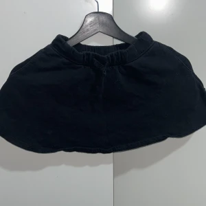 Svart kjol för barn - Säljer en enkel och stilren svart kjol för barn i storlek 122/128, perfekt för vardagsbruk. Kjolen har en elastisk midja för bekväm passform. Passar bra till både skola och fritid.
