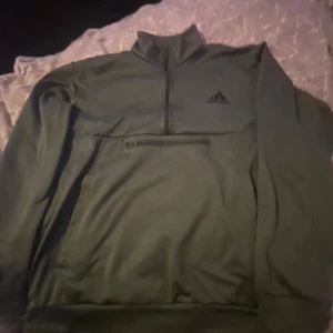 Mörkgrön Adidas Tröja - Mörkgrön adidas tröja som knappast är använd, med inga fel. Passar som den ska, nypris 700kr, priset kan diskuteras