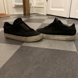  Axel Arigato lace less  - Säljer ett par svarta sneakers från Axel Arigato i bra skick. De har en stilren design med en vit sula som har lite slitage. Perfekta för vardagsbruk och passar till det mesta i garderoben. Sköna och enkla att matcha med olika outfits. De är i storlek 41 men är stora i storlekarna så passar som 42.  Tar gärna emot byten! 