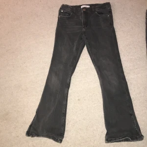 Gråa jeans från Zara - Säljer ett par gråa jeans från Zara i storlek 11-12 år. De har en klassisk femficksdesign och är i bra skick. Jeansen har en bootcut-stil som ger en snygg siluett. Perfekta för både vardag och fest!