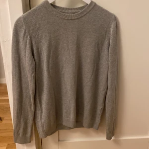 Grå tröja i kashmir - Säljer en supermjuk grå tröja. Perfekt för kyliga dagar med sin långärmade design och ribbade detaljer vid hals och ärmslut. Passar både till vardags och lite finare tillfällen. 