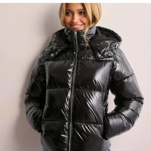 Svart glansig pufferjacka - Säljer den väldigt eftertraktade jackan från Nelly, har använt den ett fåtal gånger men inga defekter💕