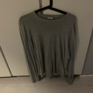 Grå tröja från Filippa K - Säljer en stilren grå tröja från Filippa K i storlek M. Tröjan är långärmad och har en klassisk rund halsringning. Perfekt för både vardag och lite finare tillfällen. Supermjuk och bekväm att ha på sig!