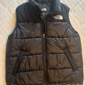 Svart North Face väst  - Säljer en svart dunväst från The North Face i fint skick. Logga både fram och back. Nypris ca 2200