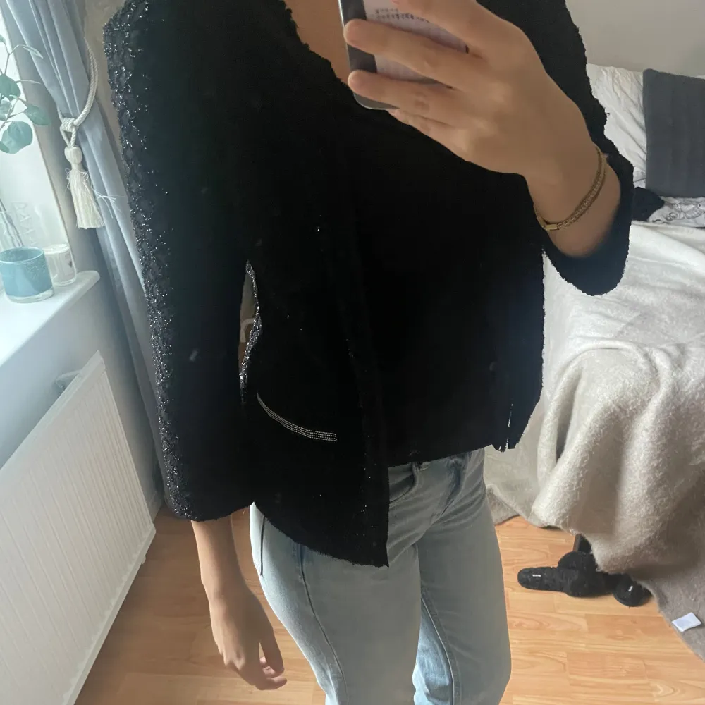 Säljer en snygg svart glittrig kavaj/kofta med trekvartsärm. Perfekt för festliga tillfällen! Den har en elegant passform och är superbekväm att bära. Passar perfekt till både jeans och klänning. Den är knappt använd!✨. Tröjor & Koftor.