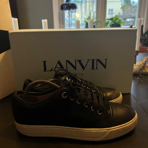 Svarta matta sneakers från Lanvin - Säljer ett par stilrena svarta sneakers från Lanvin. Kvitto + Box + dustbags, följer med. Skorna är storlek 39 men skulle säga att de passar 40-41, tanke på att man går upp ungefär 1-2 storlekar i lanvins. De är okej skick då det syns att det är använda och jag har slitit på sulan och lite på toe-capen, men lädret är jätte fint ovanpå! Tveka inte att skicka en fråga eller fundering till mig. 